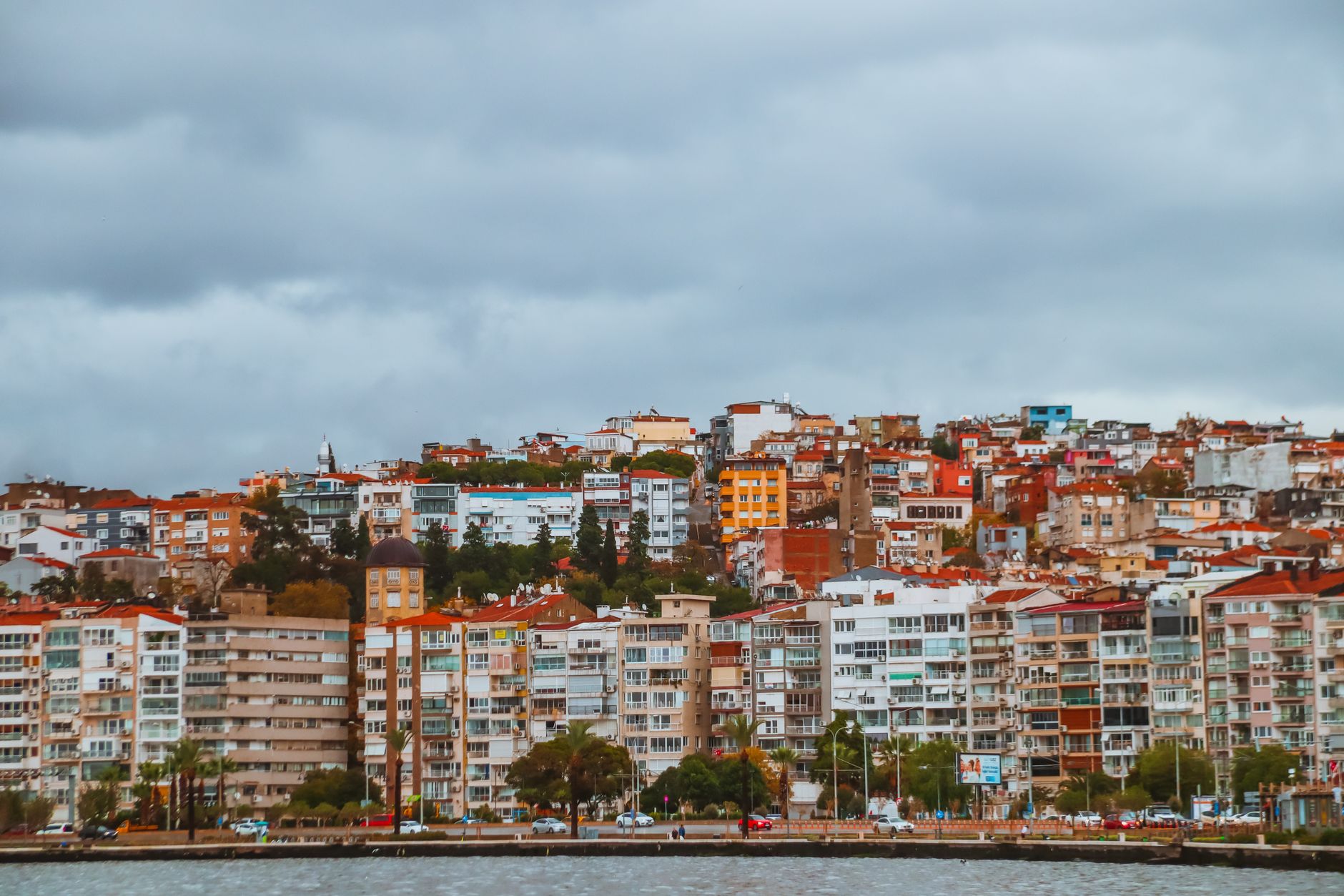 Vibrant hillside cityscape overlooking the waterfront under an overcast sky.