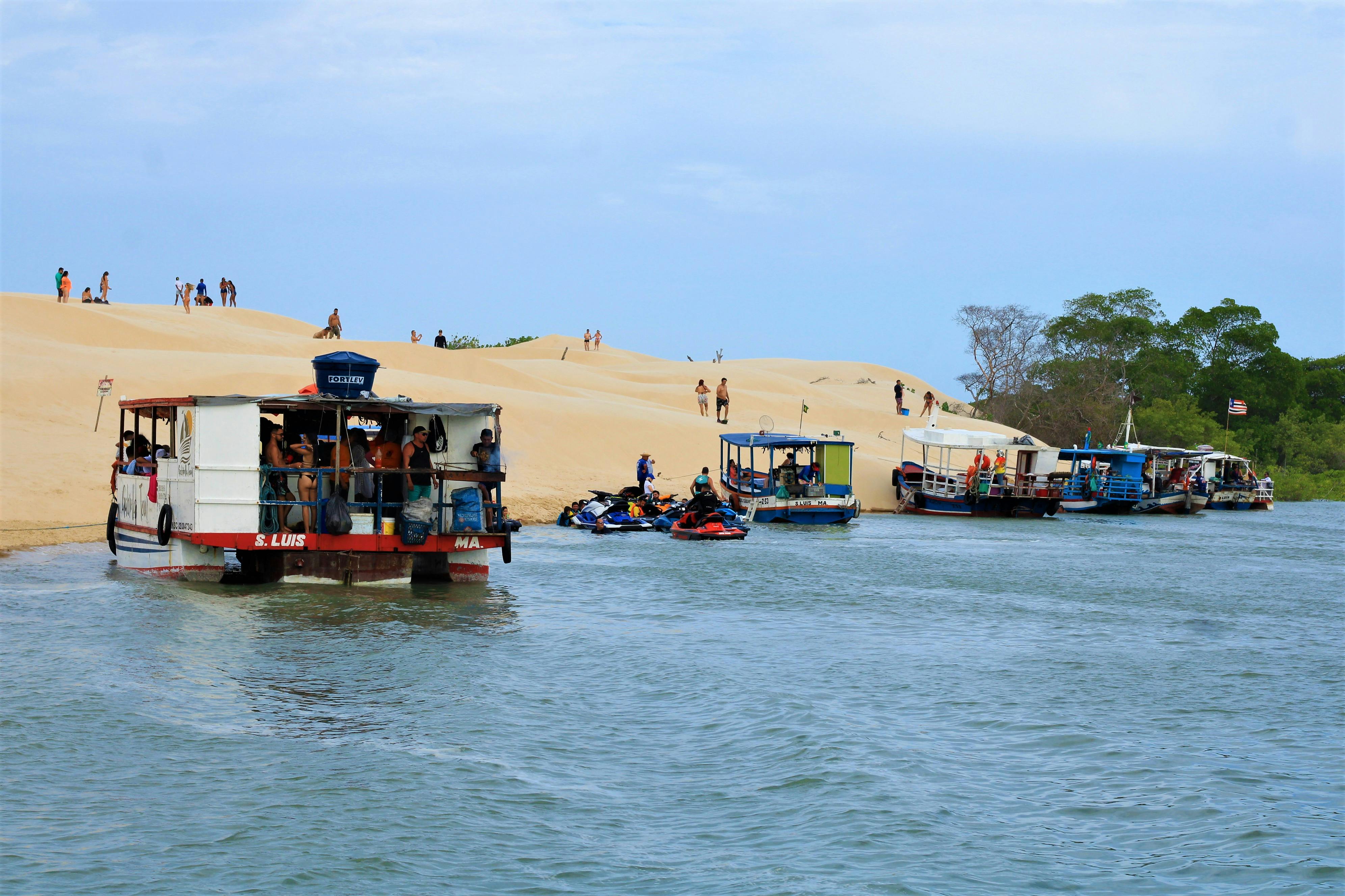 Prescription Goggle Inserts - Scene of tourists on ferries and sand dunes by a river. Perfect summer leisure setting.