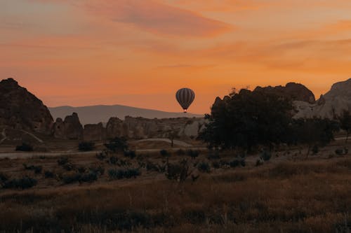 Hot Air Balloon Flying over the Mountains of Cappadocia at Sunset