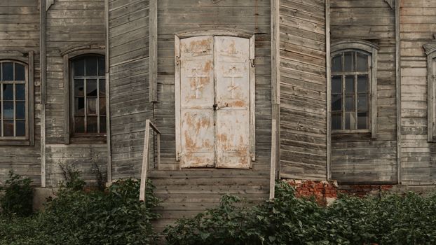 Close-up of an abandoned wooden church with rustic texture and old doors.