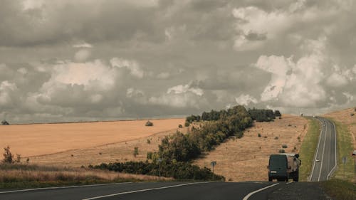 Kostnadsfri bild av bilar, dramatisk himmel, fält
