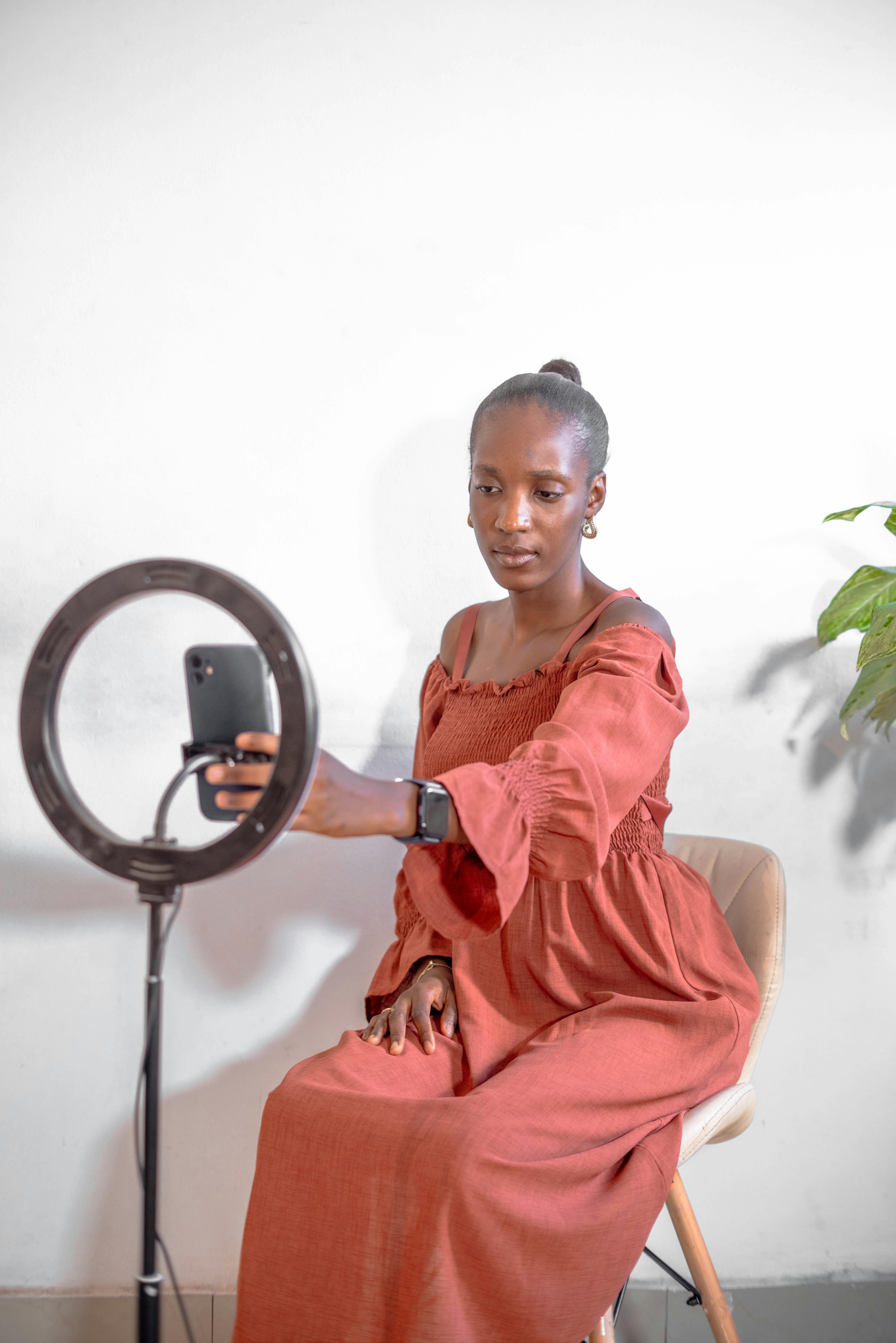 a woman sitting in front of a mirror holding a phone