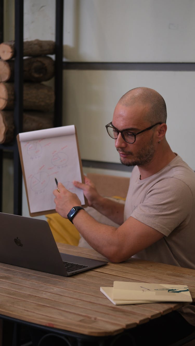 Man Working With Laptop And Showing Notes