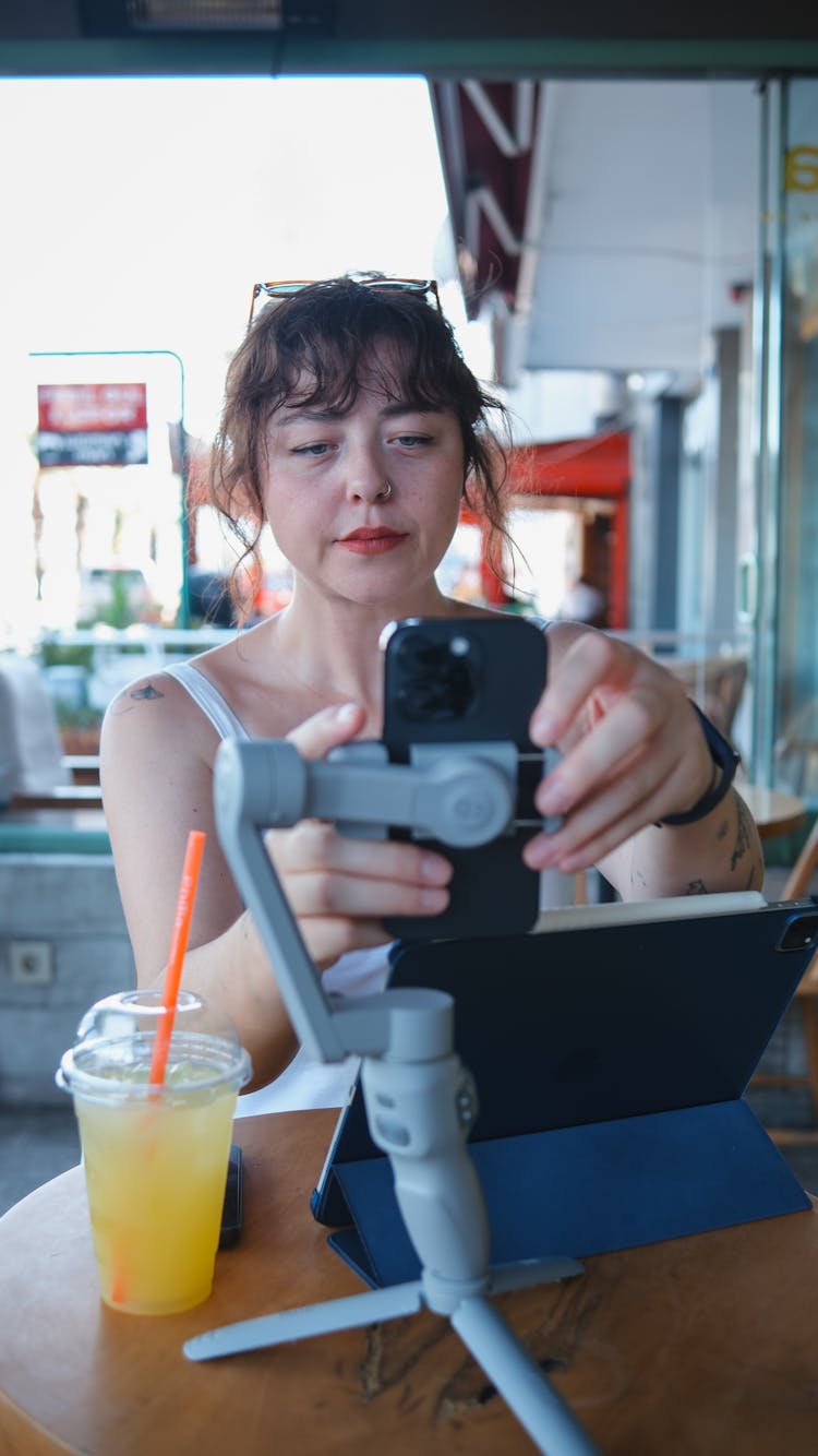 Woman Working On Tablet And Phone In Restaurant