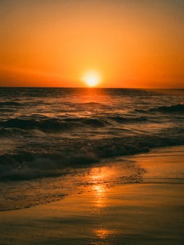 Experience the serene beauty of a Mazatlán sunset on the beach with golden reflections and gentle waves.