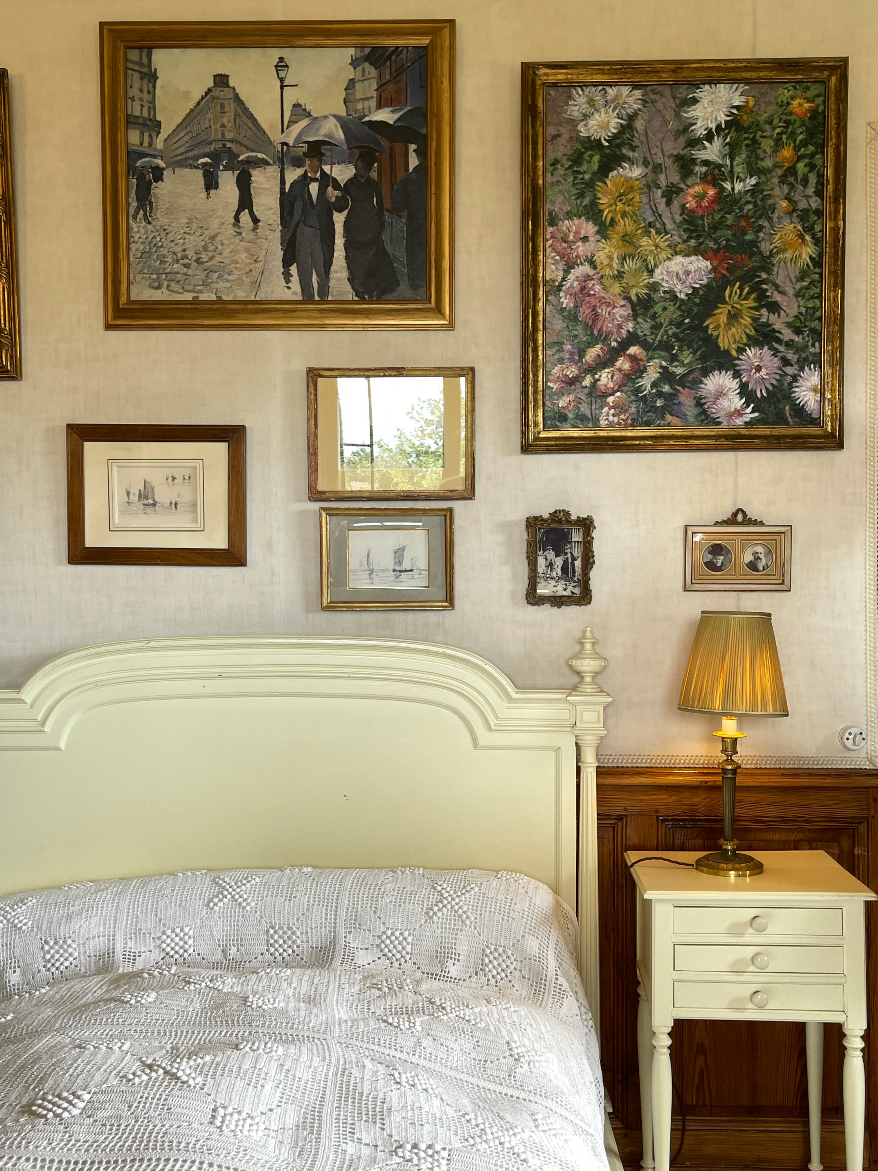 A cozy vintage bedroom featuring classic paintings and elegant decor.