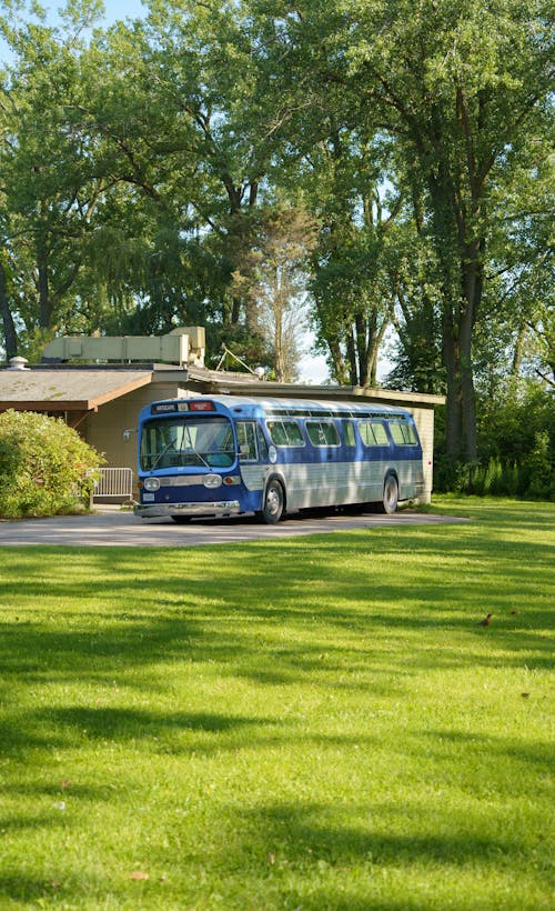 View of a Bus Driving on a Street near a Park 