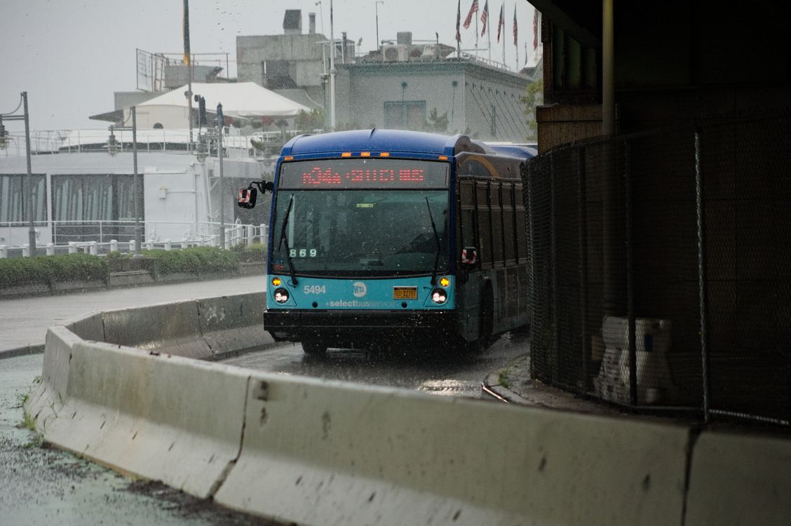 235 Bus Raining A bus is driving down a street in the rain · Free Stock Photo