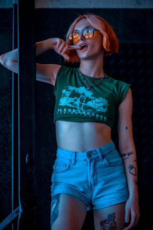 Young Tattooed Woman Wearing Shorts, a Crop Top and Sunglasses