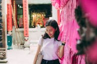 节日期间，一名妇女微笑着摆放色彩缤纷的寺庙装饰品