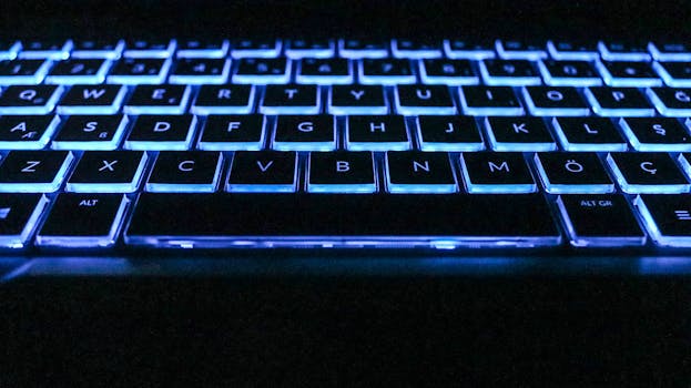 Close-up image of a glowing keyboard with blue backlighting, capturing modern technology essence.