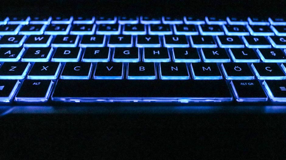 Close-up image of a glowing keyboard with blue backlighting, capturing modern technology essence.