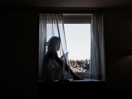 Woman Sitting on Windowsill