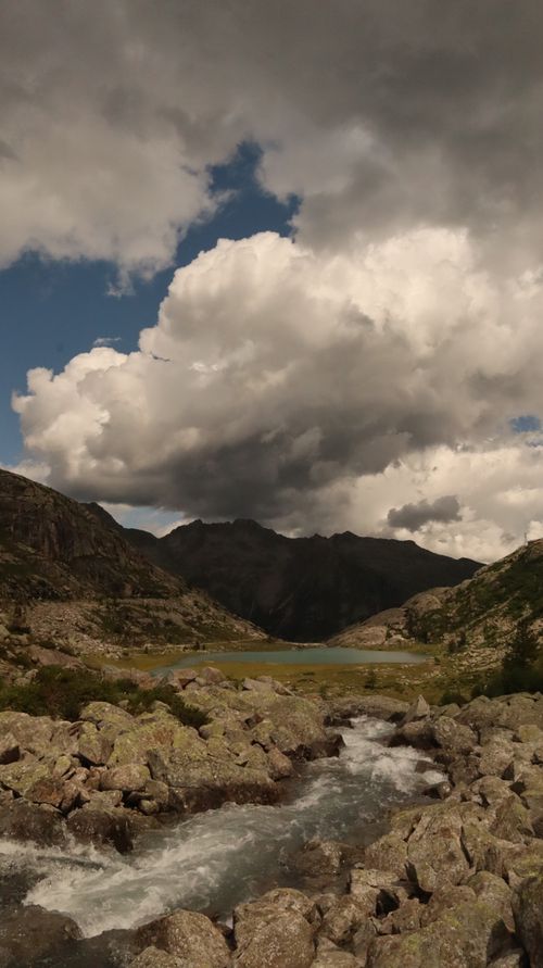 Free Capture of a scenic lake and dramatic clouds in the Dolomites, Italy. Ideal for travel and nature themes. Stock Photo