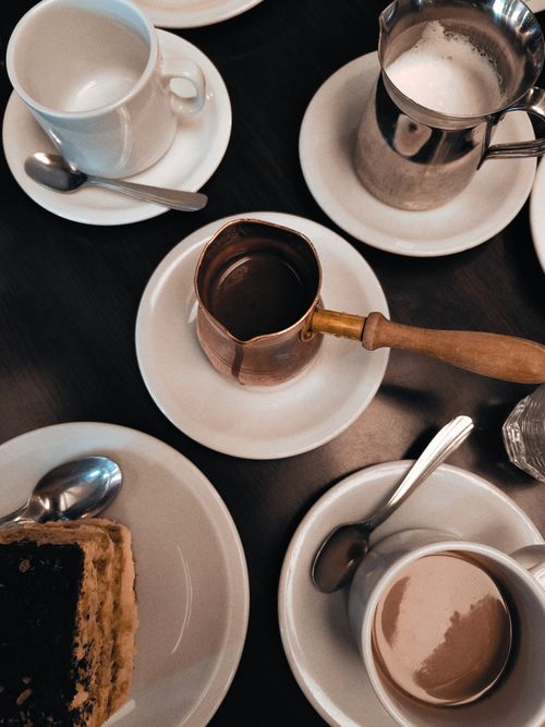Free A sophisticated coffee table setup with cups, saucers, and a slice of cake in Buenos Aires, Argentina. Stock Photo