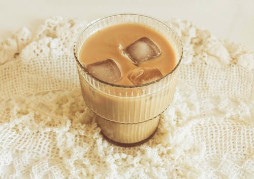 A glass of iced coffee with ice cubes