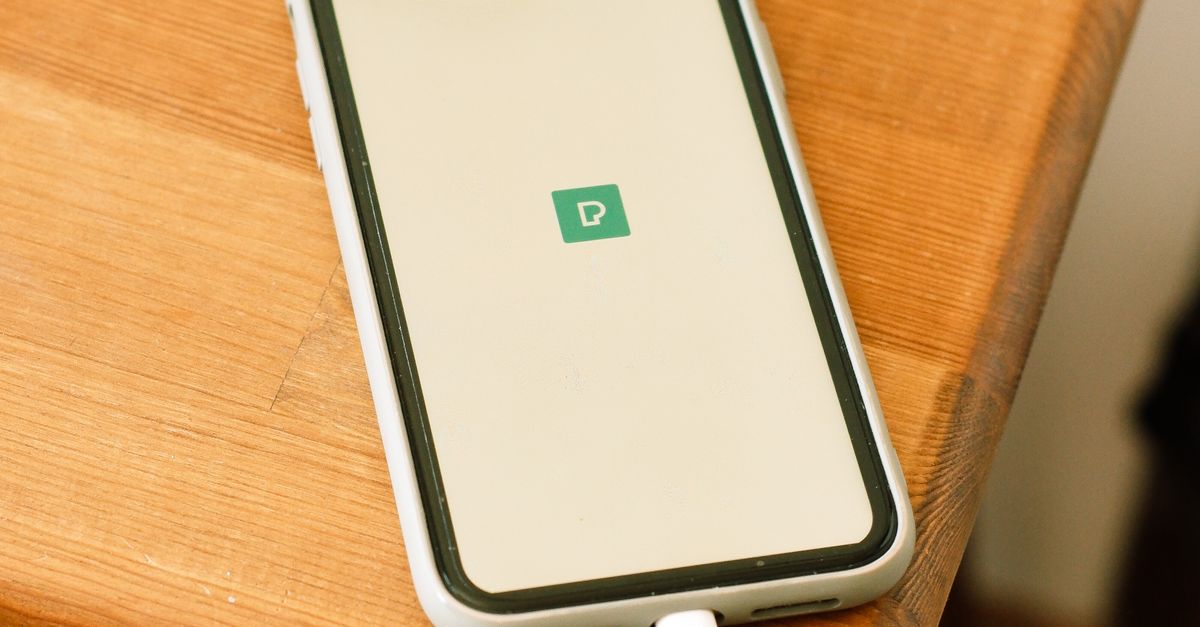 Telefon podłączony do ładowarki na stoliku nocnym