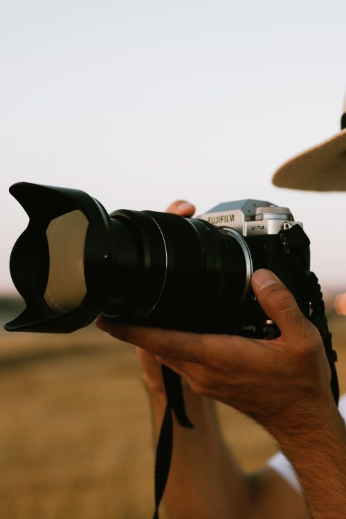 Free Photographer holding a camera outdoors, capturing a moment in nature. Stock Photo