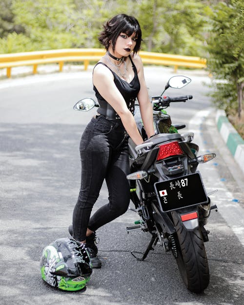 Woman Posing with Motorbike on Road