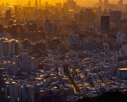 A stunning drone shot capturing a dense urban cityscape glowing at sunset.