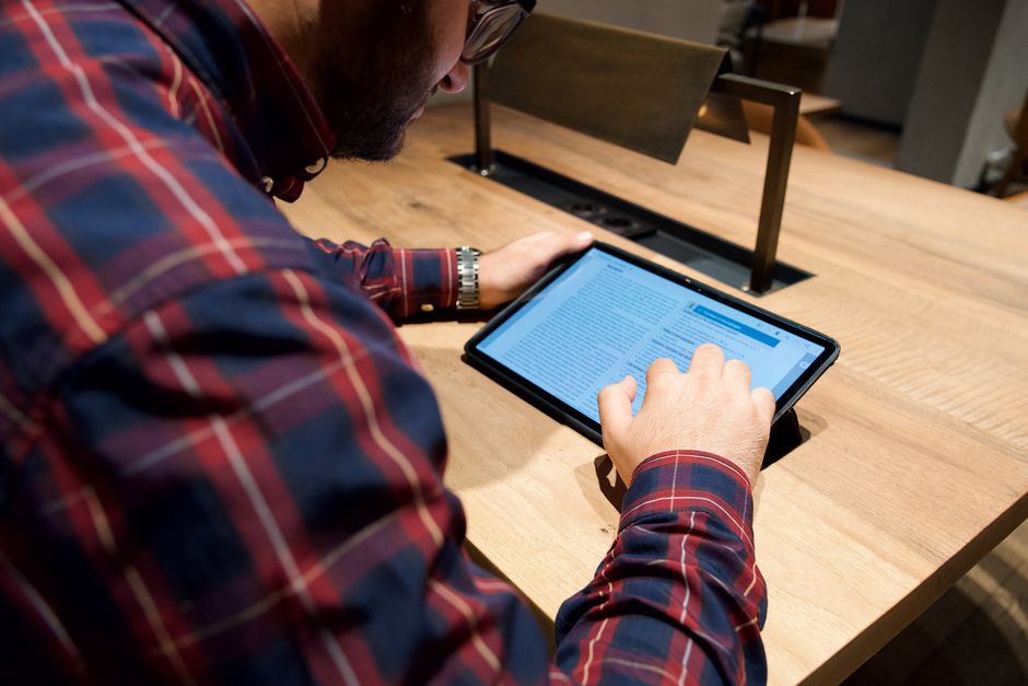 Homeowner using a digital tablet to calculate roofing dimensions - roof replacement cost calculator Homeowner using a digital tablet to calculate roofing dimensions - roof replacement cost calculator