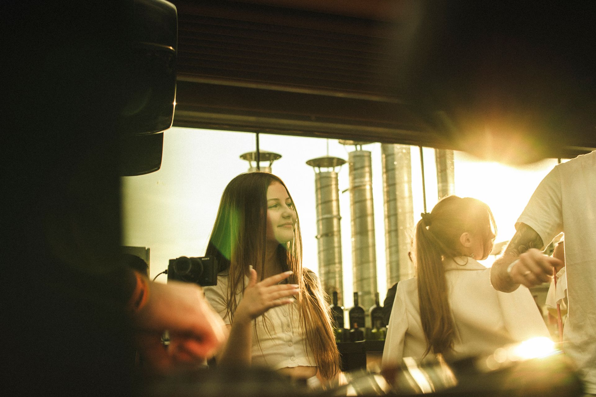 A joyful outdoor gathering at a sunlit bar in Lviv, Ukraine, capturing the warmth of summer.