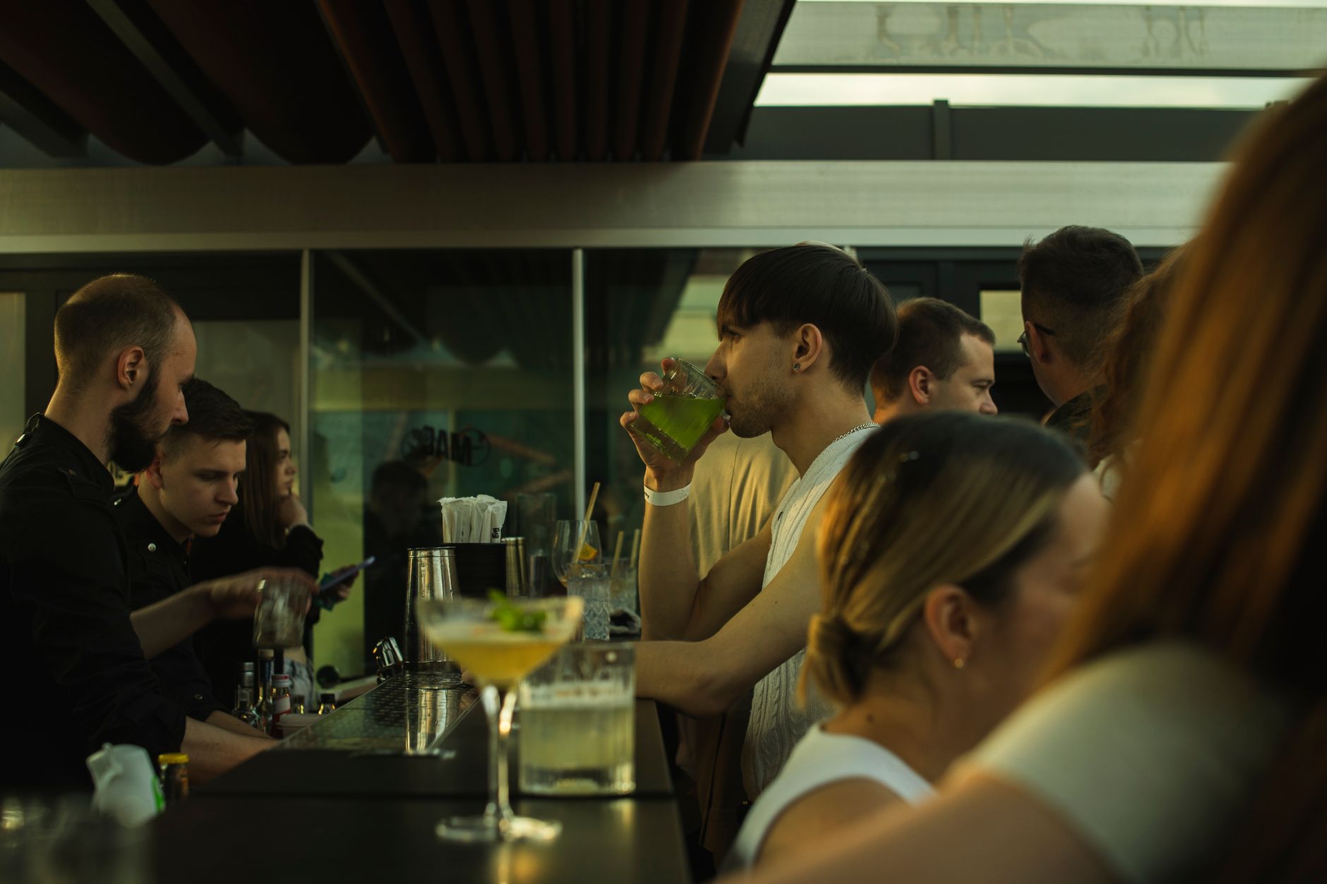 A bustling bar scene with people enjoying drinks and engaging socially.