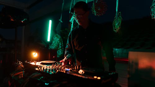 DJ Playing Sound Mixer in Dark