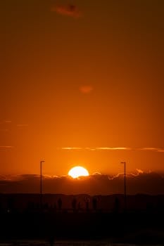 Captivating sunset with silhouettes under a warm, dramatic sky.