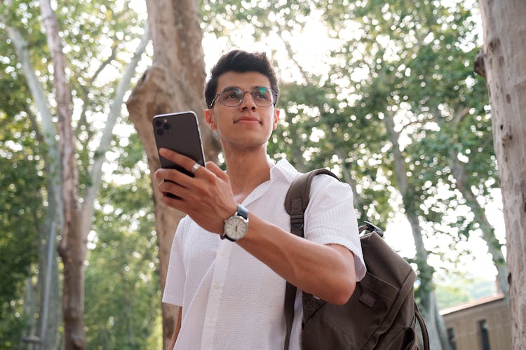 Young Student With Backpack And Smartphone