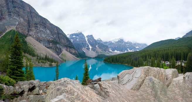 Serene landscape of Moraine Lake with Rocky Mountains and coniferous forest.