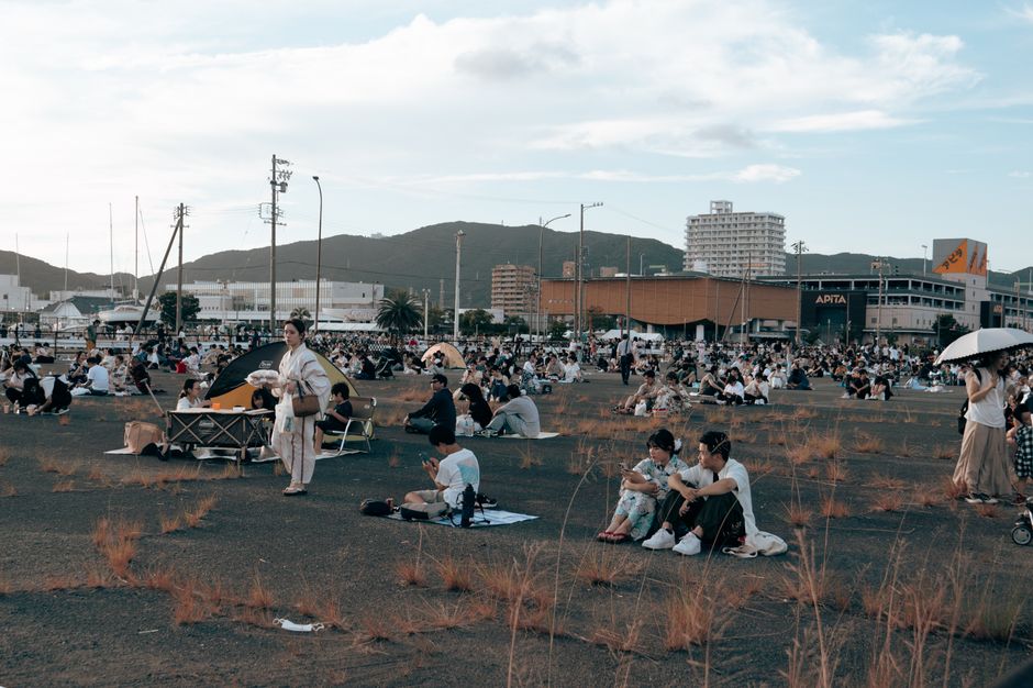 人々が日本の蒲郡で、晴れた夏の日に屋外イベントを楽しんでいます。