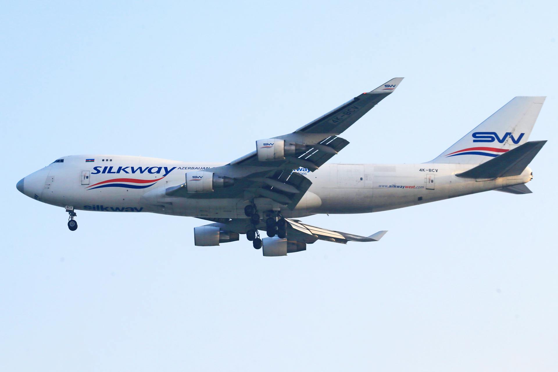 A dynamic capture of a SilkWay Airlines Boeing 747 flying in a clear sky.