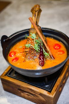 Delicious lamb shank curry with vibrant spices and herbs, perfect for food enthusiasts.