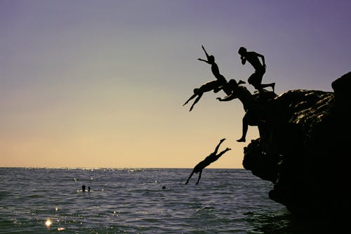 People Jumping into Sea from Cliff