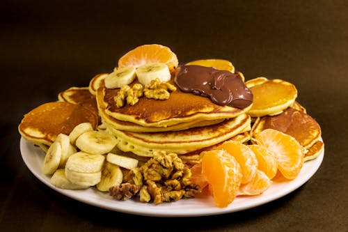 Free Pancakes with Fruit and Chocolate on Plate Stock Photo