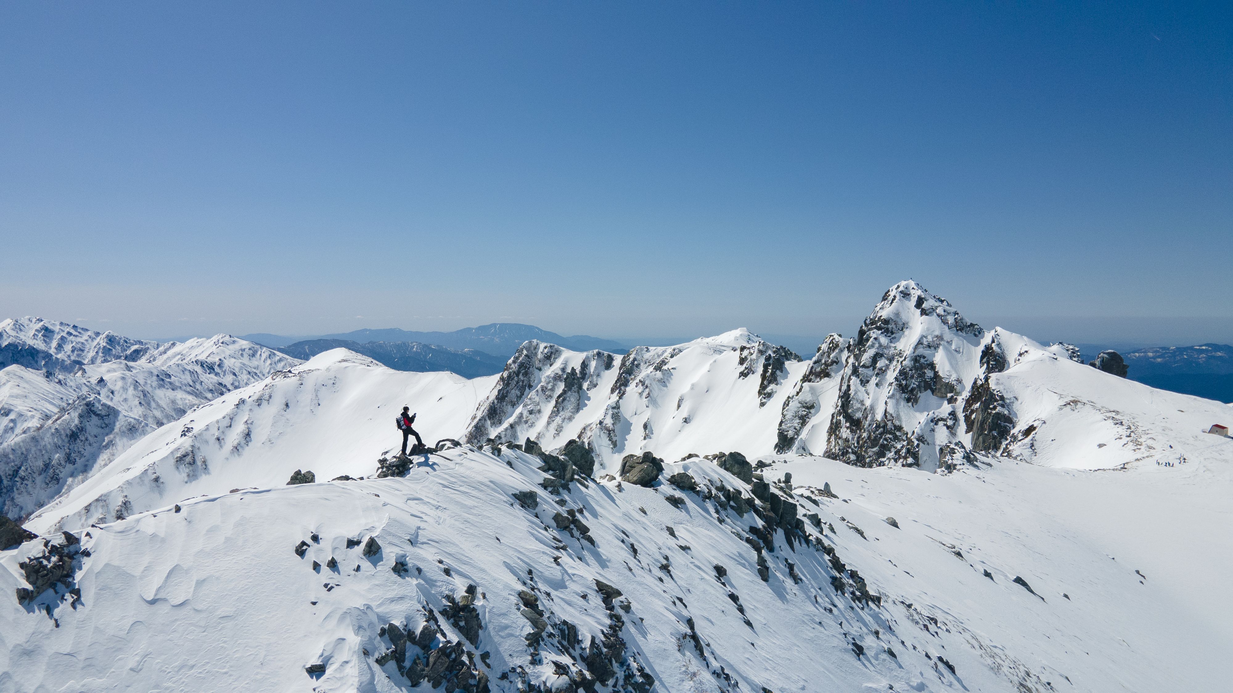 A breathtaking aerial view of a climber trekking snowy mountains in Miyada, Nagano, Japan.