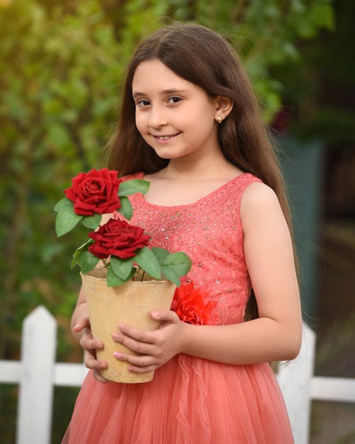 Smiling Girl in Red Dress and with Red Roses