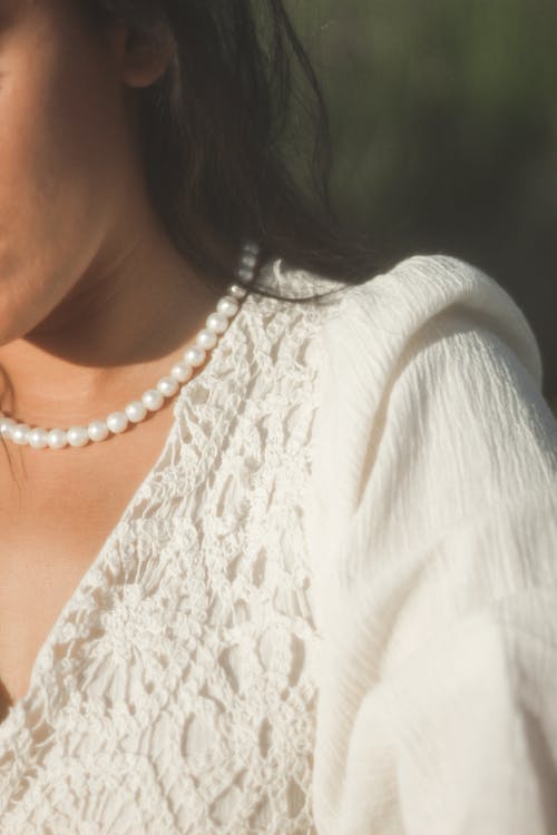 Woman Wearing a White Blouse and Pearl Necklace