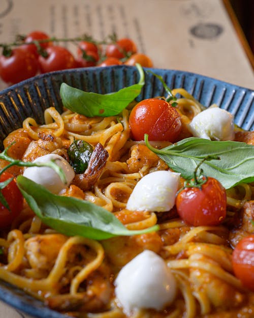 Close-up of a Pasta Dish with Cherry Tomatoes, Mozzarella and Basil