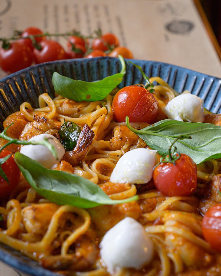 Close-up Of A Pasta Dish With Cherry Tomatoes, Mozzarella And Basil