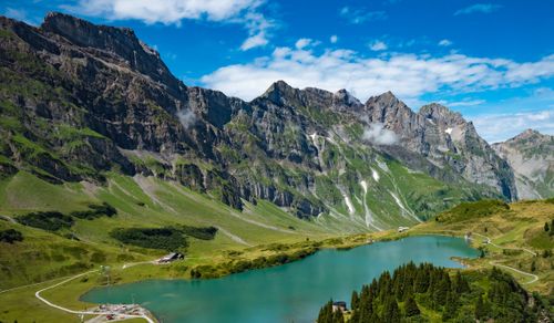 Free A stunning aerial view of the Swiss Alps featuring a serene blue lake and lush green landscape. Stock Photo