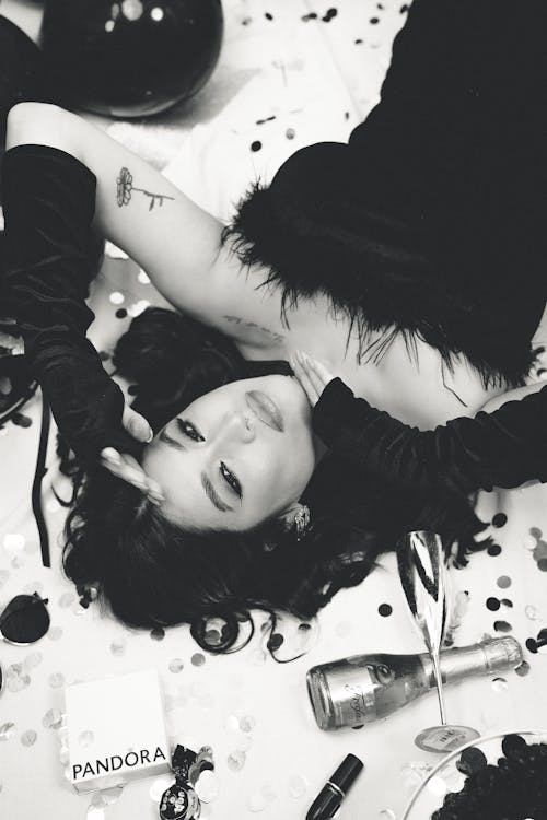 Young Woman in a Dress Lying on the Floor among Party Items 