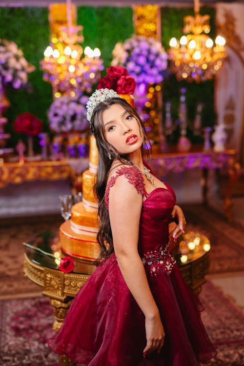 A Quinceañera Posing in a Maroon Dress 