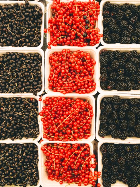 Top view of black currants, red currants, and blackberries in containers.