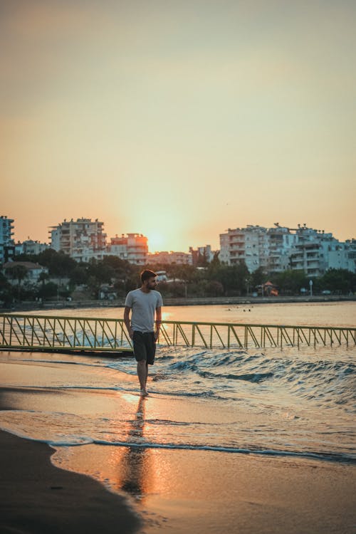 Free Photo  Young woman walking on the beach at sunset