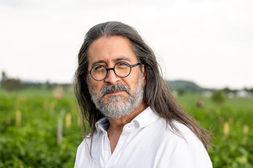 Portrait of a Bearded Man in Eyeglasses Standing in a Field