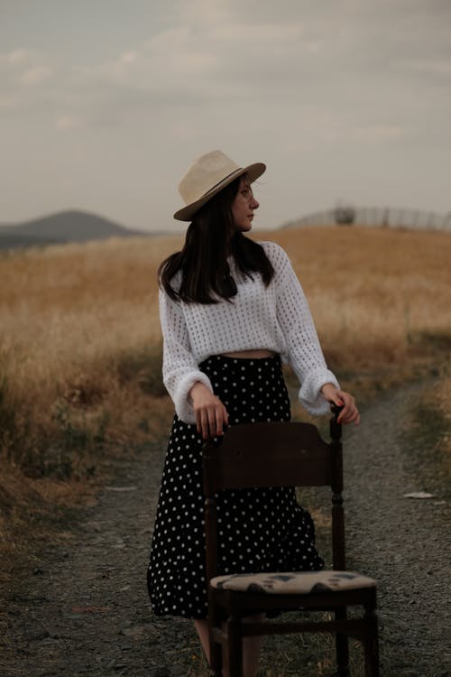 Model in a White Sweater and Fedora Looking at the Fields