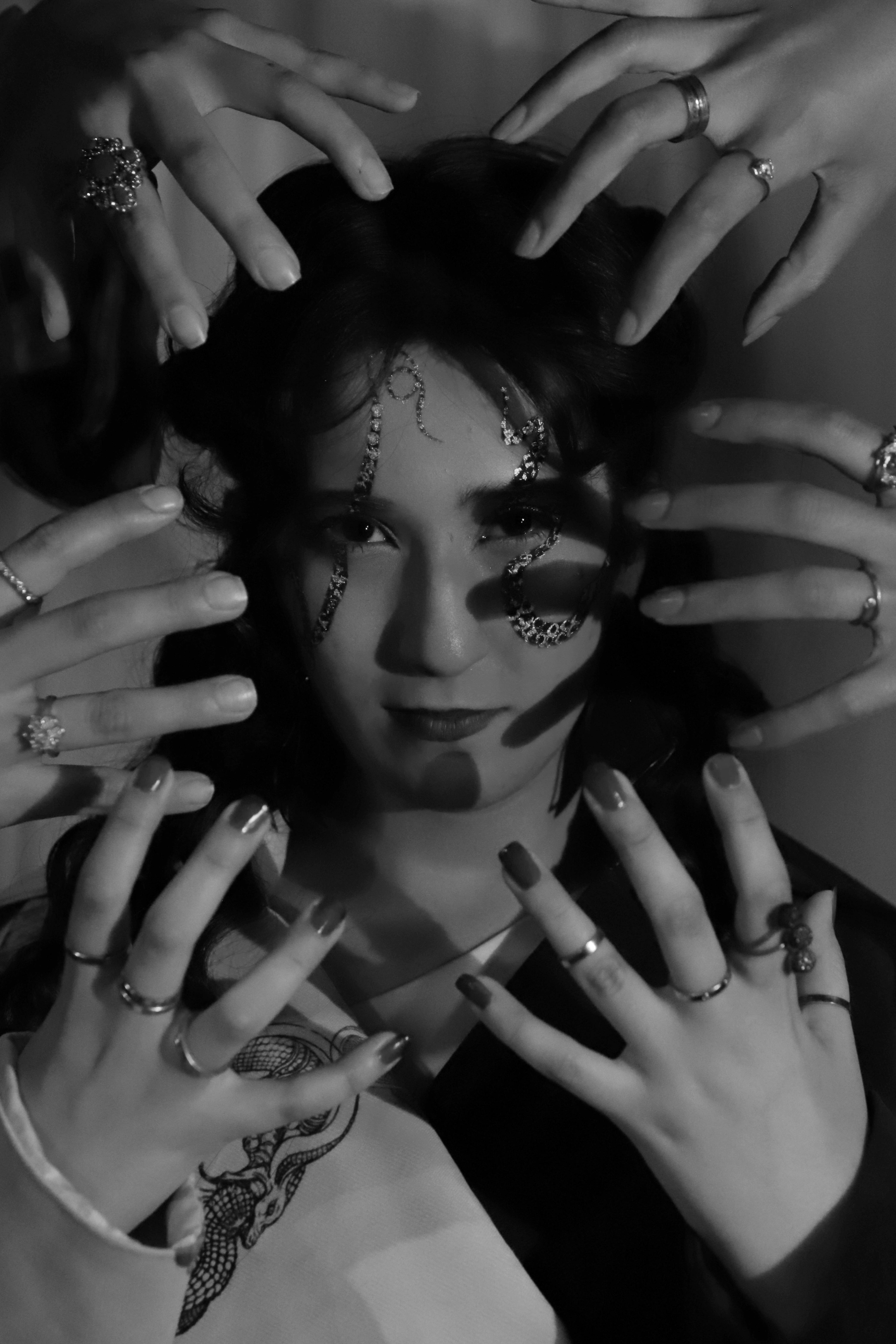 face of a woman surrounded by hands