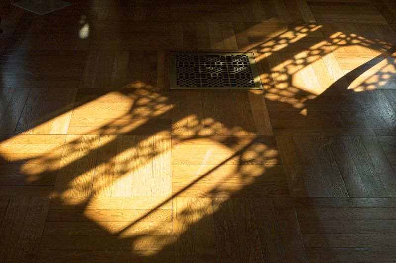 Artistic shadow patterns cast on sunlit wooden parquet flooring indoors. — Emmanuel Codden on Pexels